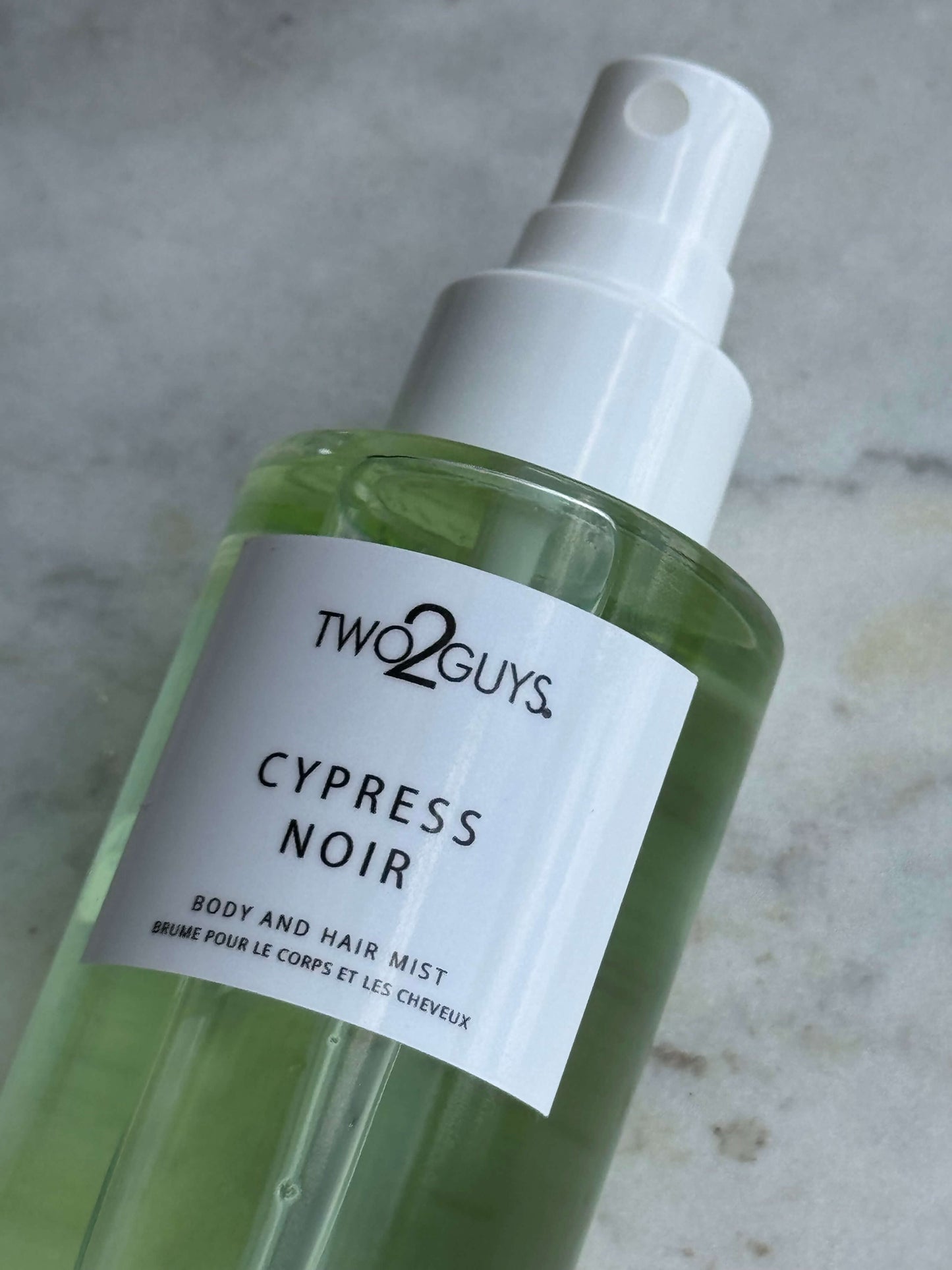 Two2Guys Cypress Noir body and hair mist bottle on a gray background with notes of rapefruit, cypress, cardamom, sandalwood, and musk