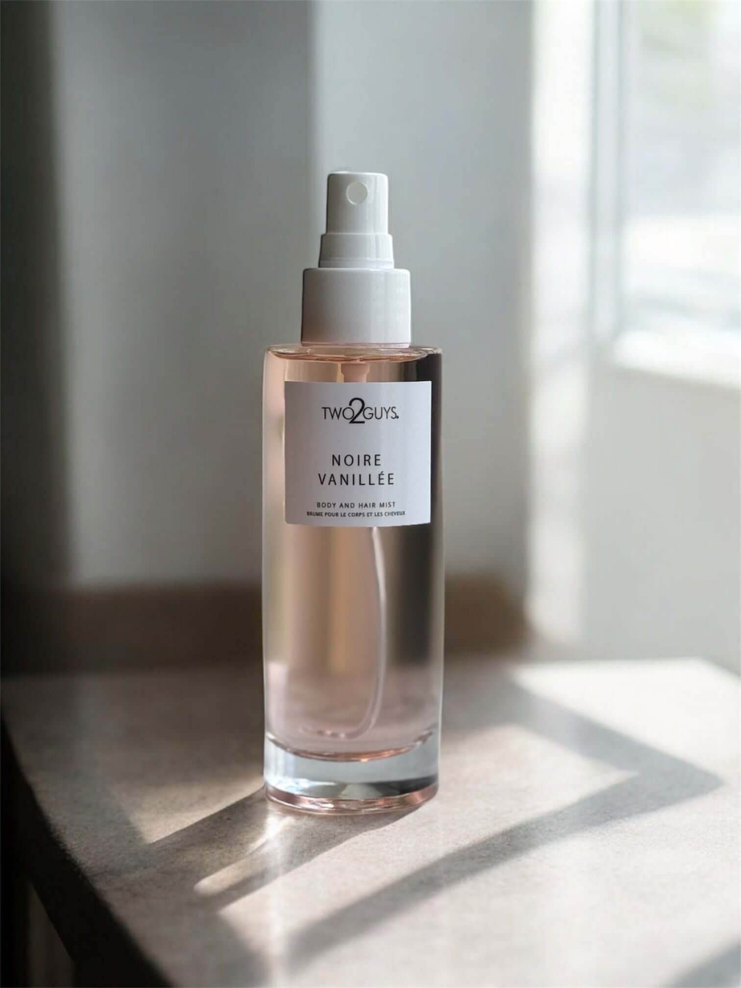 Noire Vanille body mist by TWO2GUYS on a light surface with a neutral background, notes of vanilla, jasmine, coffee, and patchouli