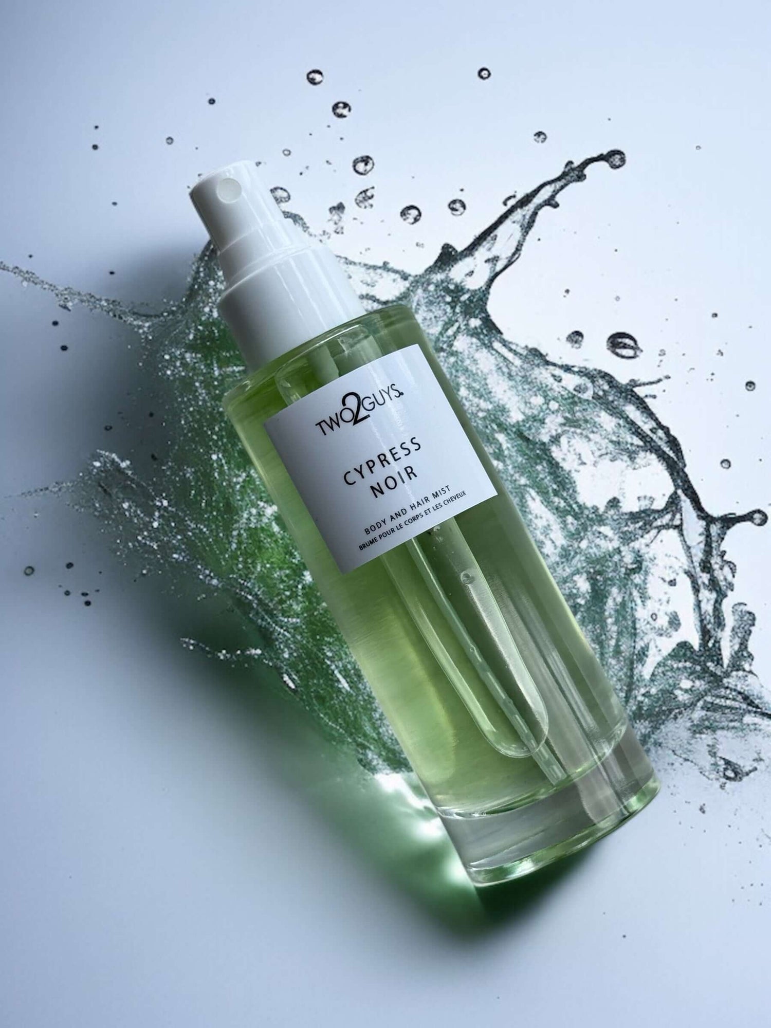 Bottle of Cypress Noir body and hair mist with water splash on a light gray background