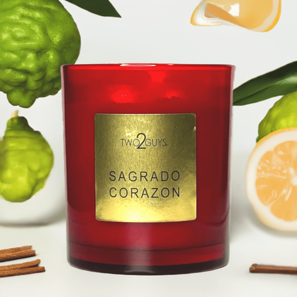 A red candle glass jar from two2guys with a gold label called Sagrado Corazon with notes of run, tobacco, bergamot and patchouli