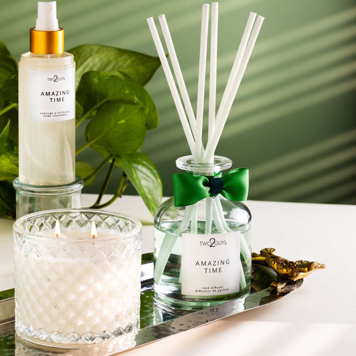 clear vintage glass and reed diffuser with a green bow and a room spray in a gold cap