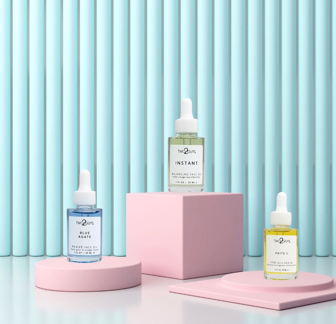 a light blue background and pink objects to hold two2guys face oils treatment instant, blue agate, and phyto II.