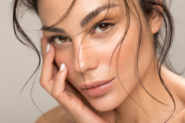 a model face closeup with a hand on her face to promote Two2Guys face oil