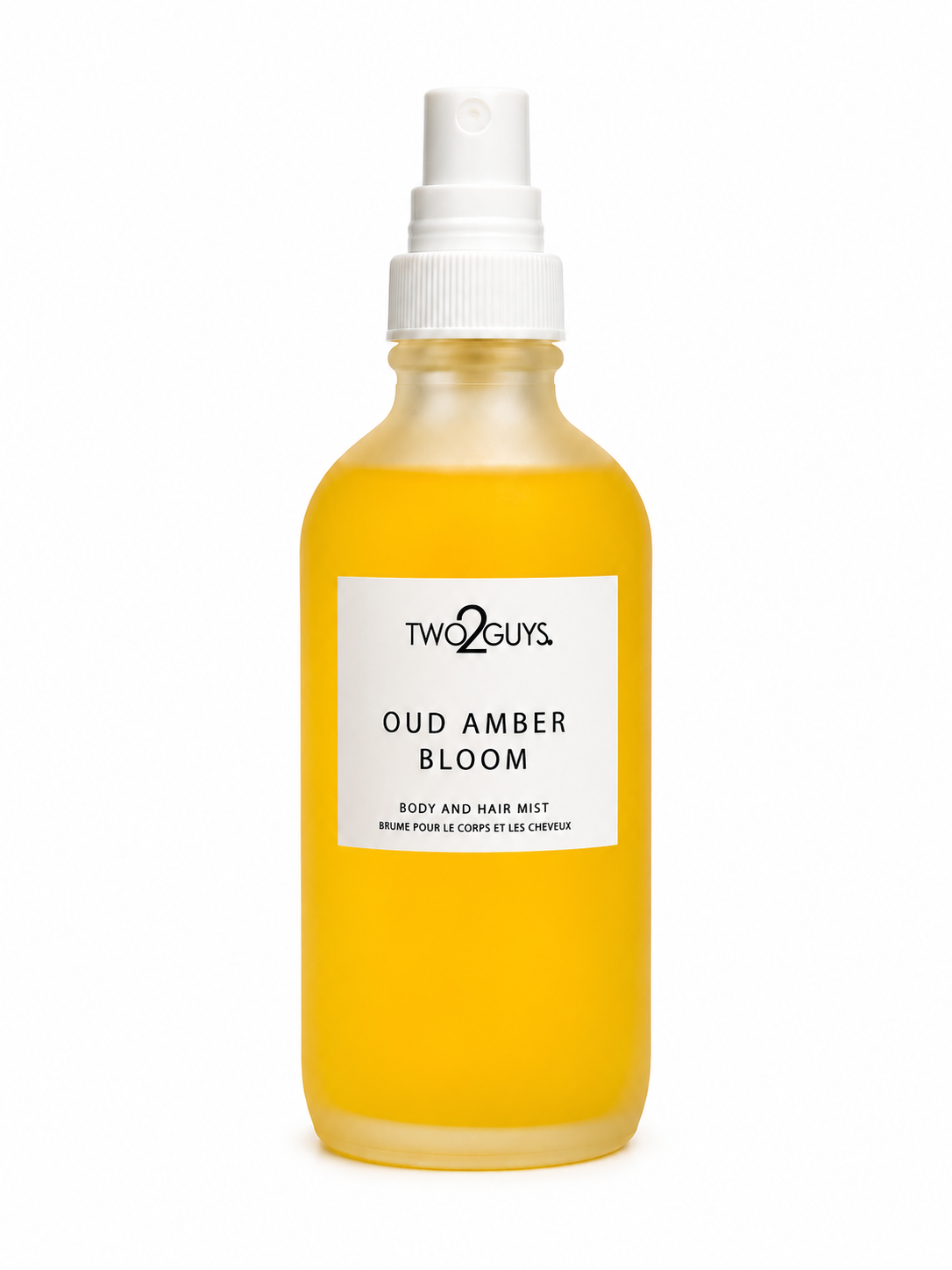 A frosted glass spray bottle filled with a golden yellow liquid, featuring a white pump dispenser and a white label with black text that reads 'TWO2GUYS OUD AMBER BLOOM'.
