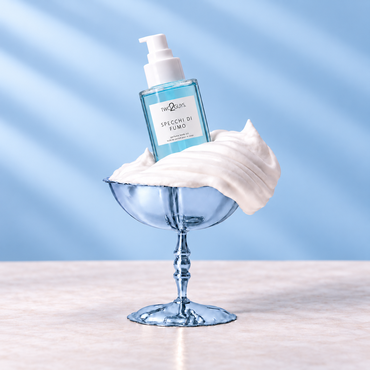 A clear glass pump bottle labeled 'the QUINTO' and 'SPECCHI DI FUMO' stands in a light blue dessert glass filled with whipped white cream, set on a pale surface against a soft blue background.